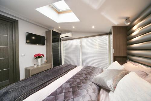 a bedroom with a large bed and a skylight at Langery Residence Central Apartments in Odesa