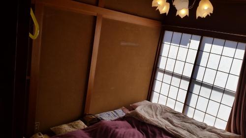 a bedroom with a bed in front of a window at "Cherry House" is Direct to Narita,Haneda AP, Disney, Asakusa, Skytree Tower, Tokyo in Matsudo