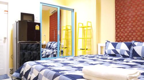 a bedroom with a blue and white bed and a mirror at Aquaman @chalong pier in Chalong