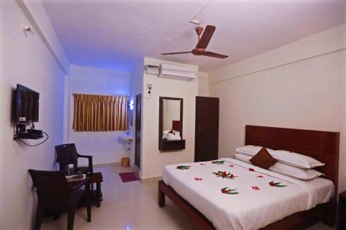 een slaapkamer met een bed en een plafondventilator bij Rani Residency in Pondicherry