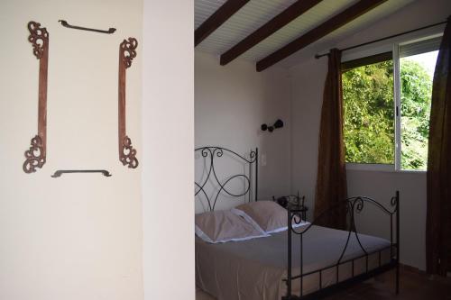Schlafzimmer mit einem Bett und einem Fenster in der Unterkunft Zandoli in Le Gosier