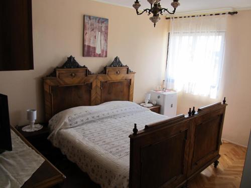 Un dormitorio con una gran cama de madera y una ventana en Sinistaj Rooms, en Dubrovnik