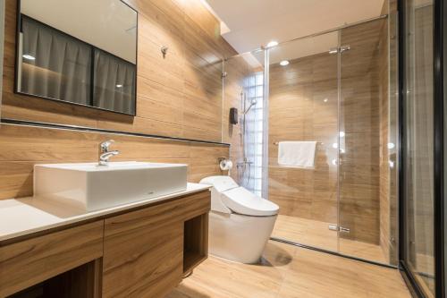 a bathroom with a toilet and a sink and a shower at Grange Inn in Taitung City