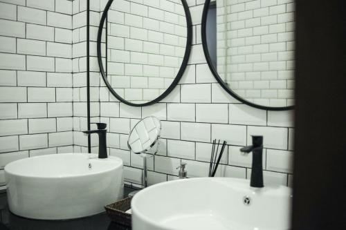 La salle de bains est pourvue de 2 lavabos et de 2 miroirs sur le mur. dans l'établissement Signature coffee & bed, à Chiang Mai