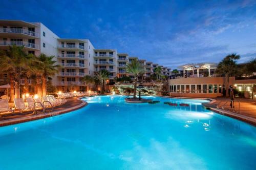 a large swimming pool in a resort at night at Waterscape Resort by Tufan in Fort Walton Beach