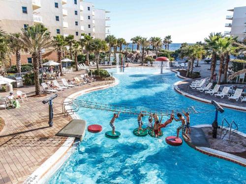 una piscina en un complejo con gente jugando en él en Waterscape Resort by Tufan, en Fort Walton Beach