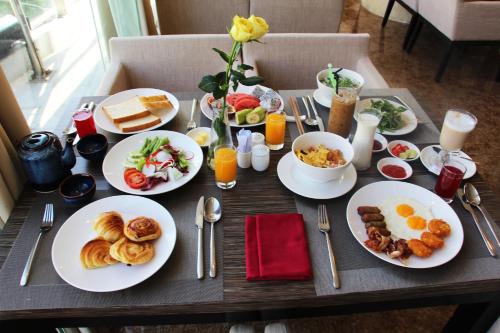 a table with plates of breakfast food on it at Avatar Danang Hotel in Da Nang