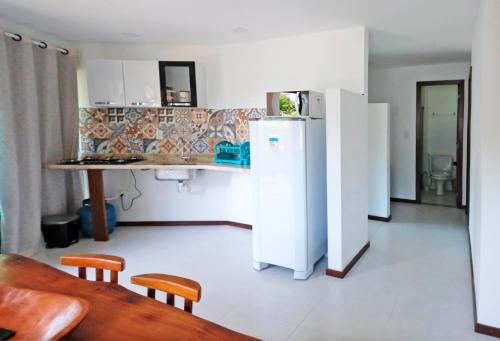 een keuken met een koelkast en een tafel en stoelen bij Casa Marilù in Morro de São Paulo