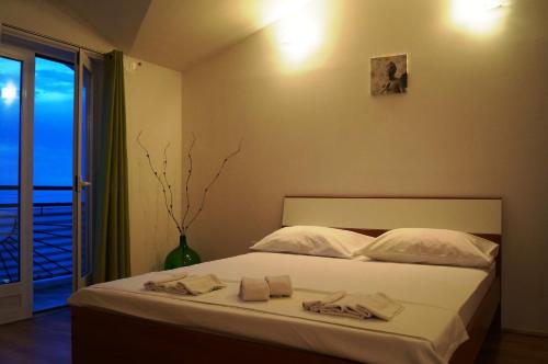 a bedroom with a bed with towels on it at Apartments Mateljak in Gradac