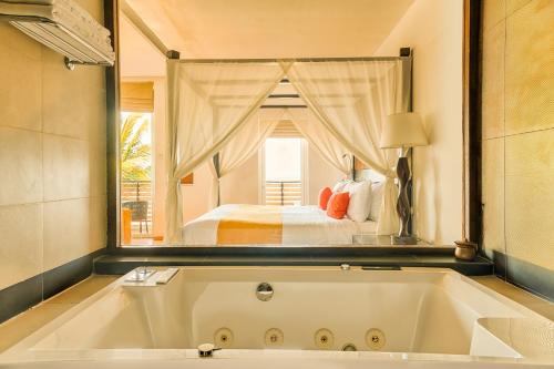 a large bath tub in a room with a bed at Jetwing Sea in Negombo