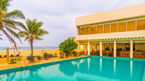a resort with a swimming pool next to a beach at Jetwing Sea in Negombo