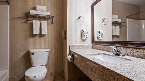 a bathroom with a toilet and a sink and a mirror at Best Western Annawan Inn in Annawan