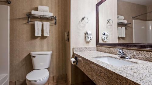 y baño con aseo, lavabo y espejo. en Best Western Annawan Inn, en Annawan