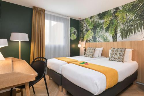 a hotel room with a bed and a desk at Hôtel Innes by HappyCulture in Toulouse