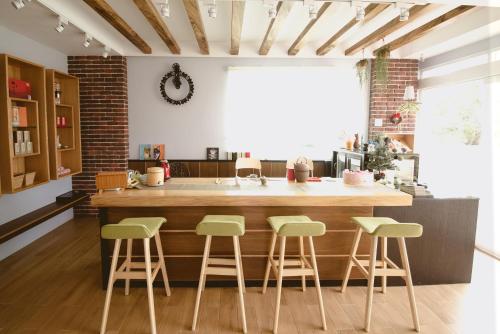 eine Küche mit einer großen Kücheninsel mit grünen Stühlen in der Unterkunft Deer Tea B&B in Longtian