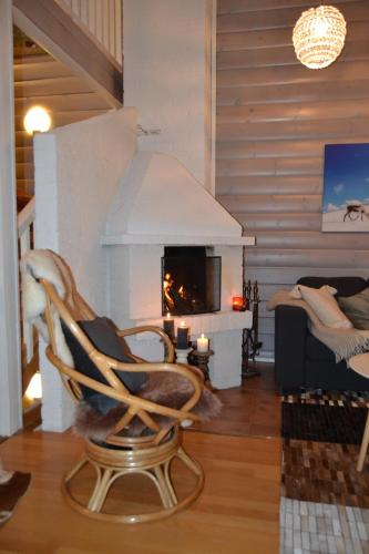 a living room with a chair and a fireplace at Chalet Suomukka in Suomutunturi