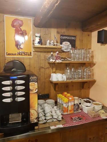 a coffee shop with a coffee maker on a counter at L'Ancien Paquier Chambre D'Hotes in Valtournenche