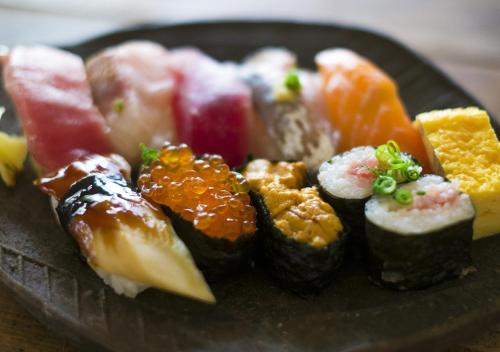 a plate of sushi and vegetables on a plate at Masugataya Ryokan in Tako