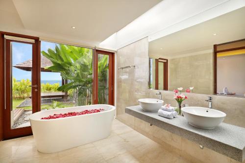 a bathroom with two sinks and a large tub at Ocean View Villa Hotman Paris VII in Jimbaran
