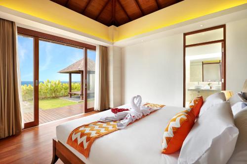 a bedroom with a bed with a view of the ocean at Ocean View Villa Hotman Paris VII in Jimbaran