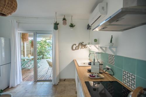 a kitchen with green and white tiles on the wall at LA BOHEME, résidence de 5 appartements avec piscine, vue océan, Petite Ile in Petite Île