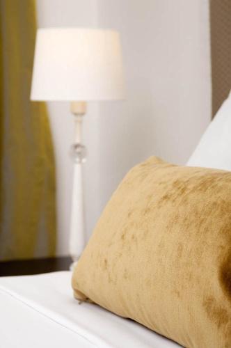 a bed with a pillow and a lamp on it at Quest on London in Hamilton