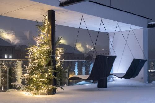 a christmas tree and a chair in a room at Hotel Burgblick, bei Burghausen in Burghausen