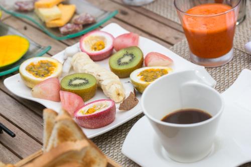 a plate of food with fruit and a cup of coffee at La Belle Tortue in Silhouette Island