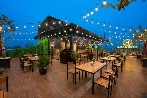 Halais Hotel في هانوي: مطعم به طاولات وكراسي واضاءات