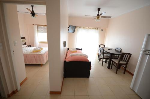 a bedroom with a bed and a dining room with a table at Apart Hotel Bs.As.Mar in San Clemente del Tuyú