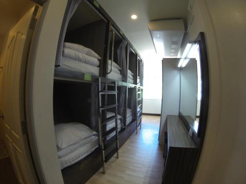 a hallway with bunk beds in a room with a mirror at Walking Street Hostel in Ko Lipe