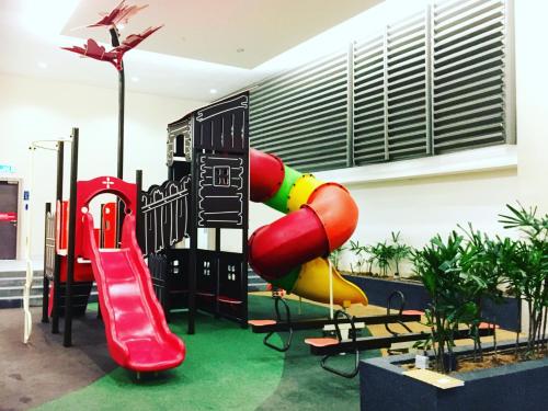 a playground with a slide in a room at JB-Singapore Paragon Suites Homestay in Johor Bahru