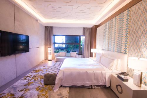 a bedroom with a large bed and a television at J Moon Villa Motel in Taipei
