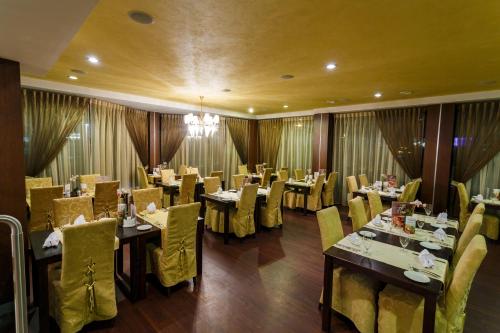 a dining room with tables and yellow chairs and tablesktop at Hotel Rocca al Mare in Tallinn