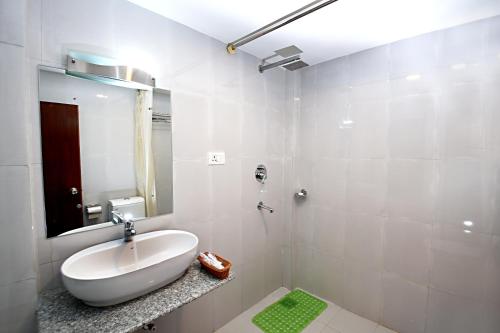 a white bathroom with a sink and a mirror at Hotel Sapana Garden Thamel in Kathmandu