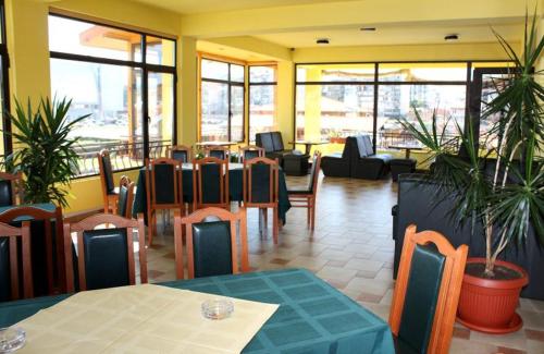 a restaurant with tables and chairs in a room at Hotel Grand in Samokov