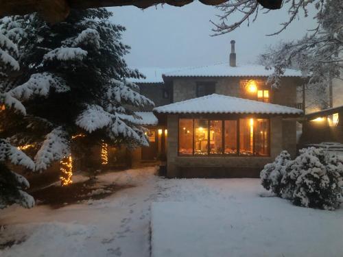 a house covered in snow at night with lights at Helydorea zen in Synikia Mesi Trikalon