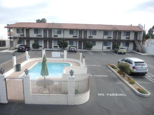 a hotel parking lot with a pool in front of a building at Cozy Inn in Costa Mesa