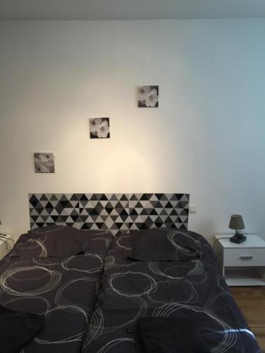 1 cama en un dormitorio con cuadros en la pared en La Forge, en Saint-Maurice-en-Cotentin