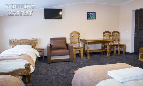 a room with three beds and a chair and a desk at Vershyna in Dragobrat