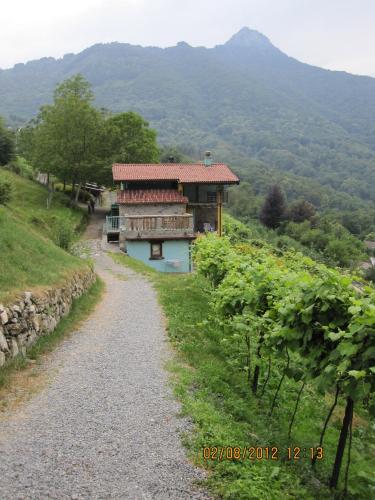 a house on a hill next to a gravel road at Agriturismo Al Marnich in Schignano