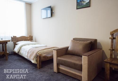 a bedroom with a bed and a chair at Vershyna in Dragobrat