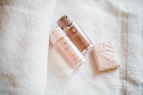 - une bouteille de cosmétiques hydratant assise sur un lit dans l'établissement NICE ETOILE AP1007 by Riviera Holiday Homes, à Nice