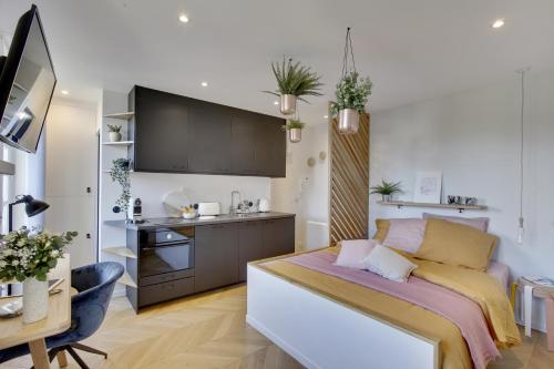 ベルサイユにあるL’Alcôve Royaleの小さなベッドルーム(ベッド1台付)、キッチンが備わります。