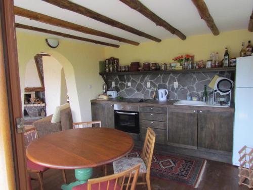 a kitchen with a wooden table and a dining room at Zinca's Cottage in Ogled