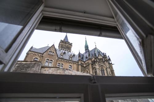 a view of a building through a window at Designpension Traumschloss Hotel Garni in Wernigerode