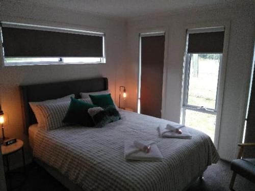 a bedroom with a bed with two towels on it at All seasons holiday homes in Tumut