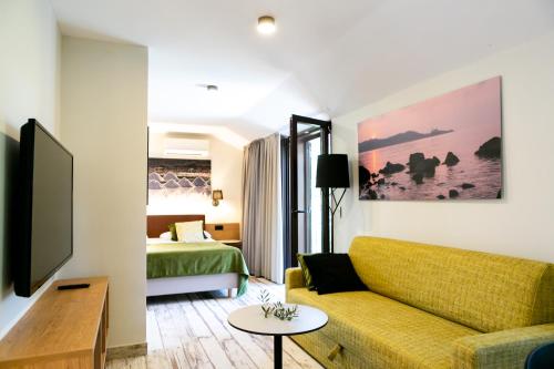 sala de estar con sofá y cama en Hotel Laguna Deluxe - Terme Krka, en Strunjan