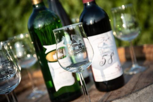 a group of wine bottles and glasses on a table at Weinschlößchen im Weingut Roos in Ilbesheim