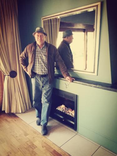 a man standing in front of a fire place at Bayswater Lodge in Bloemfontein